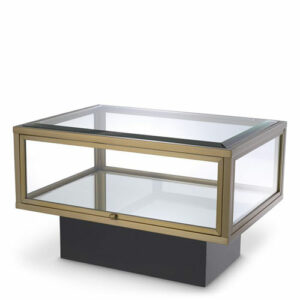 Designer Side Table Ryan by Eichholtz in brushed brass finish with clear glass and mirror glass. Features side glass door and Black base with an integrated shelf of mirror glass